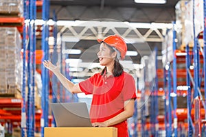 Warehouse worker working in factory warehouse industry and using laptop, Cheerful young woman working in logistics center