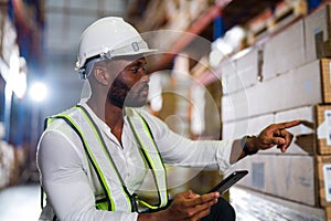 Warehouse worker working process checking the package with a tablet in a large distribution center