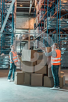 full length view of two warehouse workers working with boxes