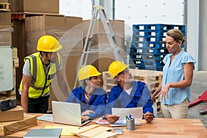 Warehouse workers discussing with manager