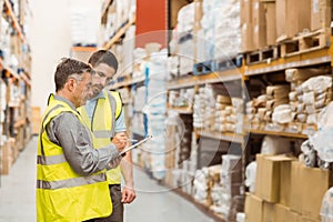 Warehouse workers talking together at work