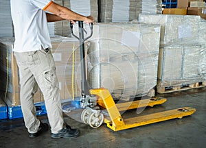 Warehouse Workers using Hand Pallet Jack Unloading Package Boxes. Commerce Supply Chain. Shipment Storage Warehouse Cargo Shipping