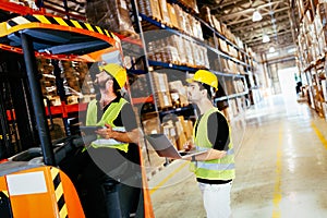 Warehouse workers working together with forklift loader