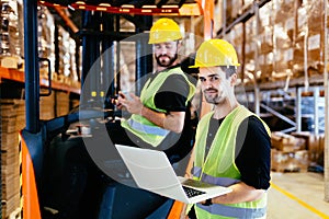 Warehouse workers working together with forklift loader