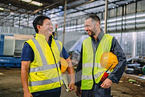 Warehouse workers in yellow hard hats, smiling and ensuring safety, exemplify a vibrant industrial atmosphere