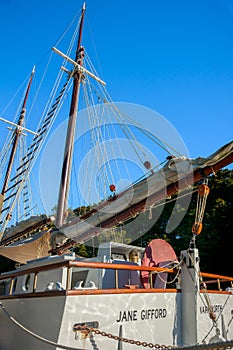 Old fashioned sailing boats moored alongside waterfront pier on Mahurangi River