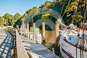 old fashioned sailing boats moored alongside waterfront pier on Mahurangi River