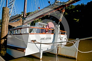 Old fashioned sailing boats moored alongside waterfront pier on Mahurangi River