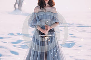 Warlike girl with dark hair in long gray vintage light dress, lady of cold and frost, bare open shoulders and sharp