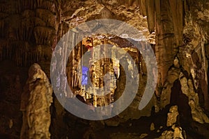 Warm abstract background of stalactites, stalagmites and stalagnates in a cave underground, horizontal