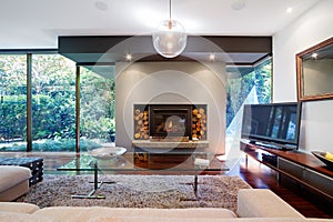 Warm Australian living room with fireplace in luxury home photo