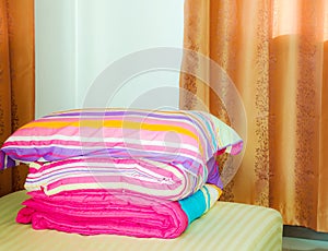 Warm bedroom with comforter and big fluffy pillow on the bed.