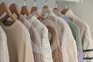 Warm beige wool pullover and knitwear and hanging in wardrobe