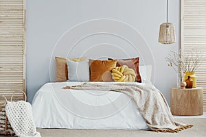 Warm blanket on white duvet in cozy bedroom interior