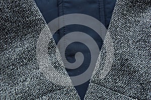 warm blue dark jacket sleeve wool fabric texture background close-up.