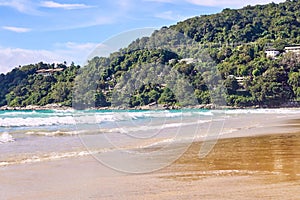 Warm blue sea. White waves. Green rock