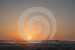 warm bright sun with mountains in the desert during sunset