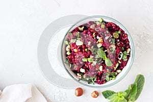 Warm buckwheat, beetroot, nuts and herbs salad, light grey concrete background. Vegetarian and vegan food.