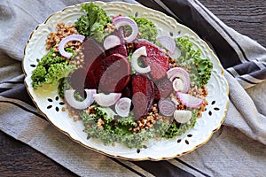 Warm buckwheat and beetroot salad on wooden background. Vegetarian diet idea and recipe -salad with beetroot, buckwheat