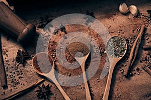 Warm colourful various spices and herbs in wooden spoons