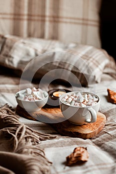 warm cozy bedroom interior with cup of hot chocolate on tray, candles christmas