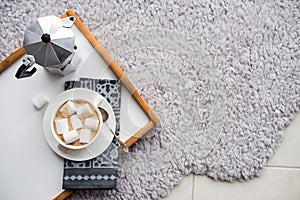 Warm cozy home. Tray and cup of coffee with marshmallows