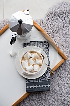 Warm cozy home. Tray and cup of coffee with marshmallows