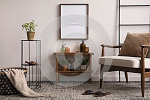 Warm and cozy interior of kitchen space with mock up poster frame, comode, boucle armchair, brown pillow, plants in flowerpot and