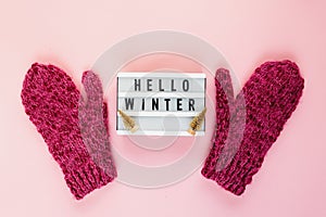Warm, cozy winter mittens, lightbox on pastel on pink background. Christmas, New Year concept flat lay.