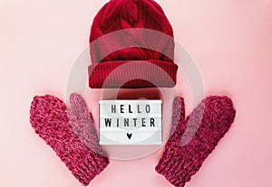 Warm, cozy winter mittens, lightbox on pastel on pink background. Christmas, New Year concept flat lay.