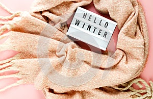 Warm, cozy winter scarf, lightbox on pastel pink background. Christmas, New Year concept flat lay.