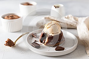 Warm Dessert Chocolate Fondant Lava Cake with ice cream scoop on the top on white plate