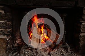 A warm and cozy fire burning in a rustic stone fireplace