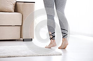 Warm floor concept. Closeup of female legs stepping by hardwood floor at home