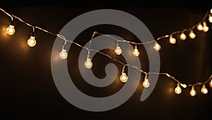 Warm glowing string lights on dark background bulbs