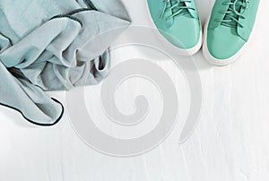Warm headscarf and shoes color Tiffany on white concrete background. Fashion and design of warm clothes