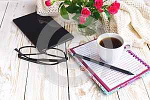 Warm knitted plaid, glasses, coffee, notebook, pensil and tablet