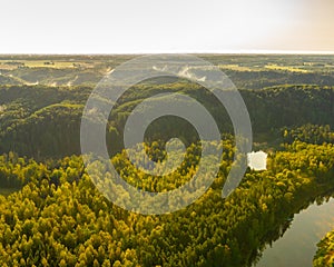 Warm morning aerial top view of river valley forest in northern europe national park