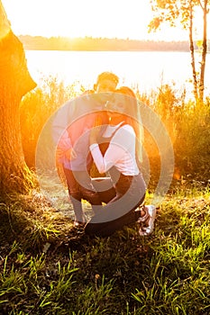 Warm Mother-Child Embrace by the Glistening Lake at Sunset