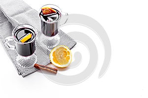 Warm mulled wine with citrus and spices for winter evening on white background copyspace