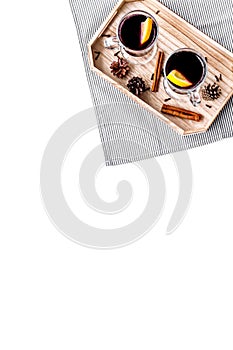 Warm mulled wine with citrus and spices for winter evening on white background top view copyspace