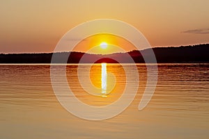 Warm orange sunset sky over Montargil lake, Portugal