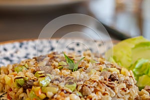 Warm pearl barley salad with meat and zucchini decorated with green lettuce leaves