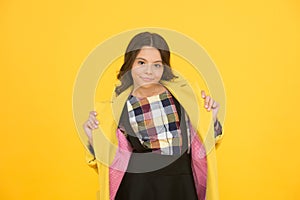 Warm and practical outerwear. Autumn look of small fashion model. Little child in cozy fashion style yellow background