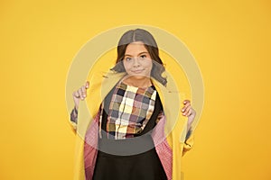 Warm and practical outerwear. Autumn look of small fashion model. Little child in cozy fashion style yellow background