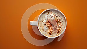 Warm pumpkin spice latte in white cup on orange background