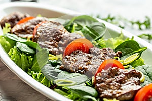 Warm salad with chicken liver, Baby spinach, tomatoes and balsamic dressing. Food recipe background. Close up