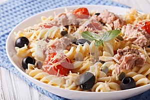 Warm salad fusilli pasta, tuna and tomatoes close up. horizontal