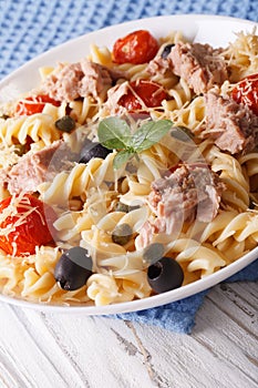 Warm salad fusilli pasta, tuna and tomatoes close up. Vertical