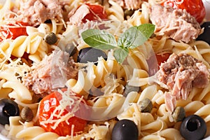 Warm salad fusilli pasta, tuna and tomatoes macro. horizontal